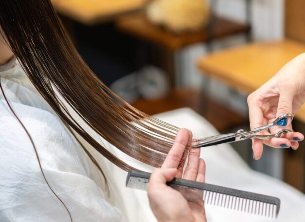 女性の髪を切っている手元